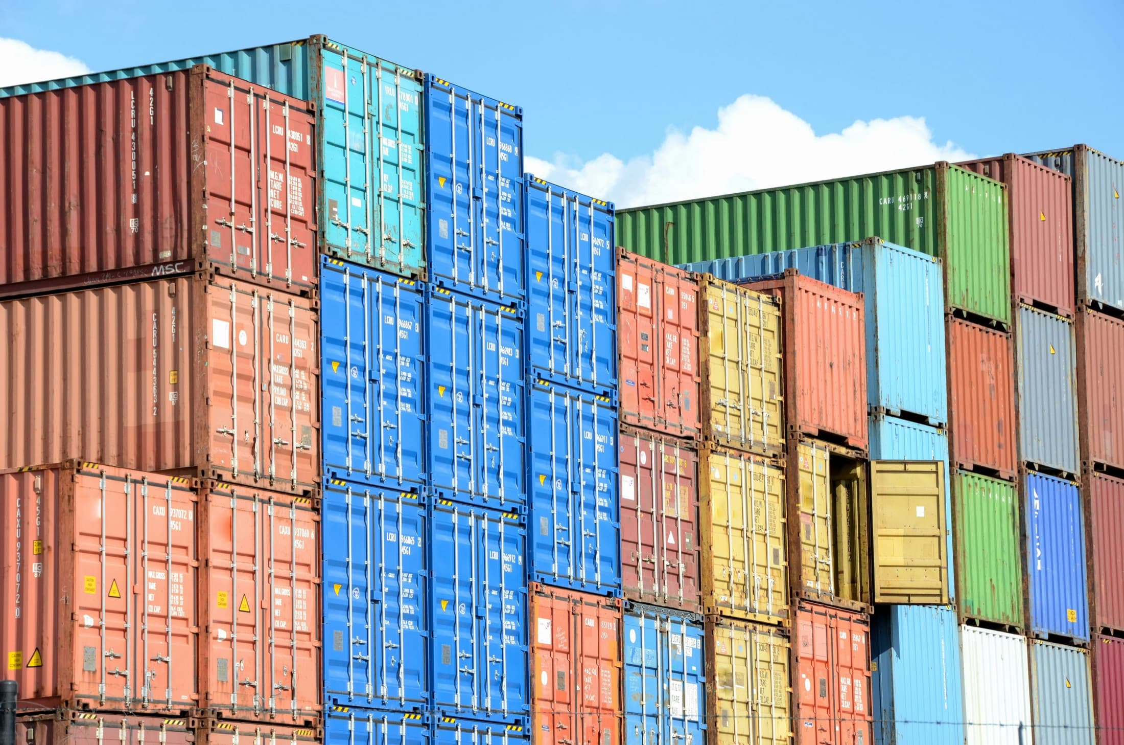 Stacks of shipping containers at a terminal, representing origin equipment and allocation pressure